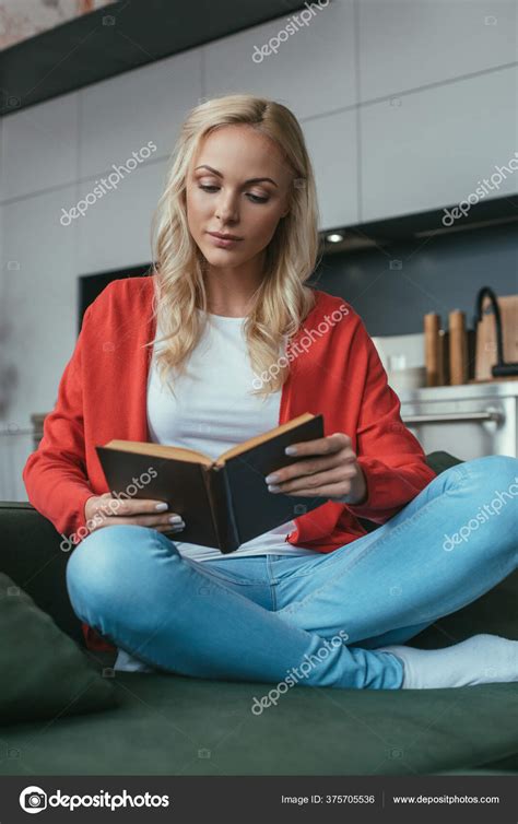 Attentive Young Woman Sitting Sofa Crossed Legs Reading Book Stock