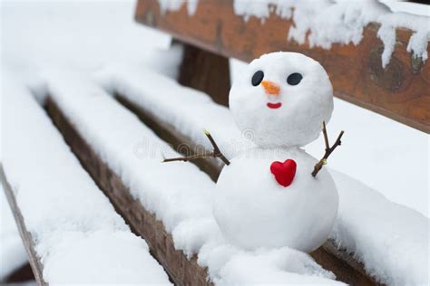 Happy Snowman With A Red Heart On A Snowy Bench Stock Image Image Of
