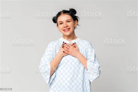 Cute Darkhaired Teen Girl Holding Hands On Heart And Smiling Express