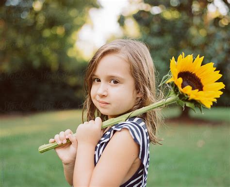 Cute Young Girl With A Big Sunflower By Stocksy Contributor Jakob