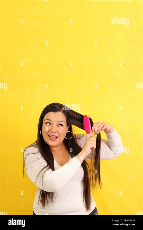 Adult 40 Year Old Latina Woman Brushes Her Hair With Difficulty Because