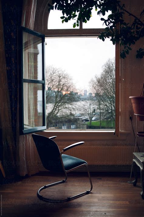 Empty chair in front of a open window with a view by Denni Van Huis ...