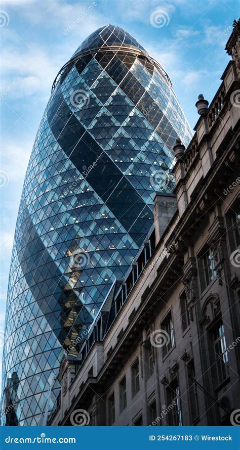 Vertical Shot Of The Gherkin Skyscraper In Daylight With Blue Cloudy