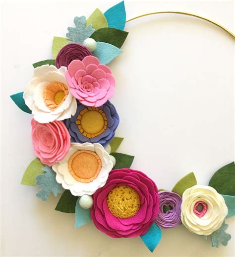 A Wreath Made Out Of Felt Flowers And Leaves