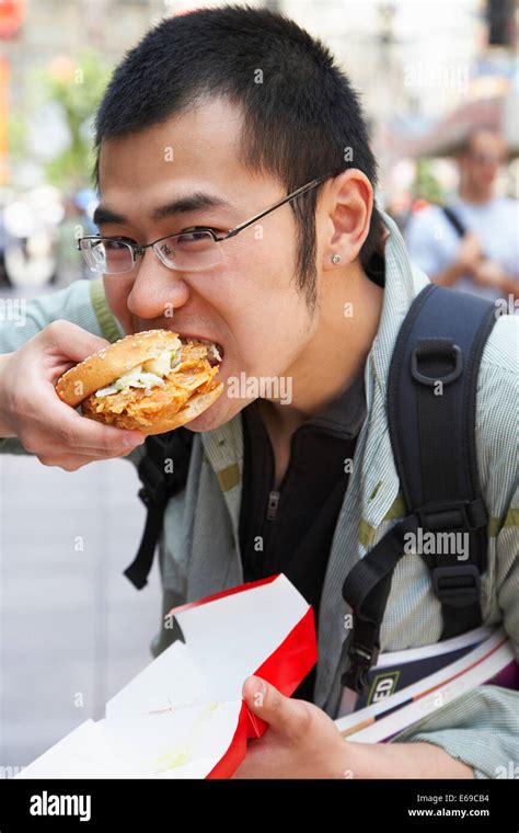 Chinese Man Eating On City Street Stock Photo Alamy