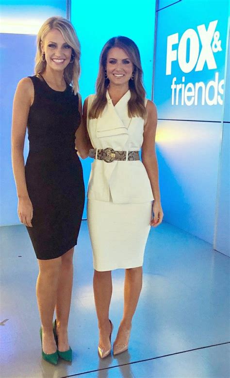 Two Women Standing Next To Each Other In Front Of A Blue Wall With The Fox And Friends Logo On It