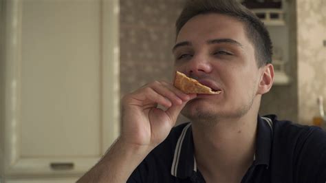 Handsome Guy Eat Pizza In The Kitchen And Enjoying It Stock Video