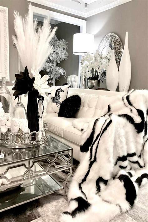 A Living Room Filled With White Furniture And Black And White Decor On