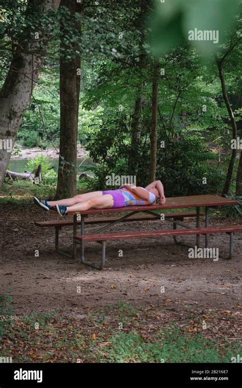 A Hiker Takes A Break Exhausted After A Days Hike On A Picnic Table