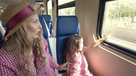 Happy Mom And Daughter Traveling Together Goes On The Train And Look Out The Window Stock