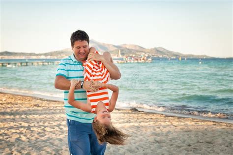 Father Playing With His Daughter On The Evening Beach Stock Image