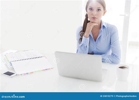 Businesswoman Looking Bored In Front Of Laptop And Television Stock