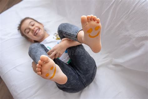Close Up Of Little Girl`s Feet Painted With Smiles Stock Photo Image