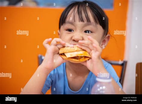 Chino Asia Niña Comiendo Hamburguesa En Un Restaurante Interior Fotografía De Stock Alamy