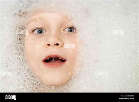 lustige porträt gesicht von der blonden kind junge unter wasser im bad mit schaum von shampoo