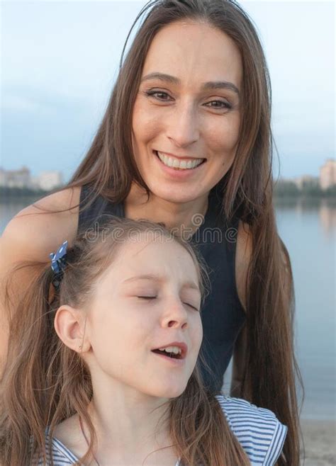 mom and daughter in front of the camera woman smiles beautifully and looks at us girl is very