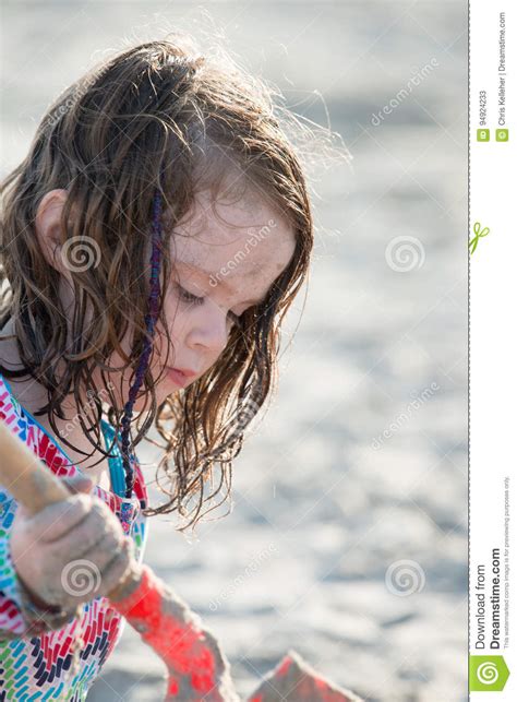Het Jonge Meisje Spelen Met Het Zand En Het De Bouwzandkasteel Bij Het Strand Dichtbij Het