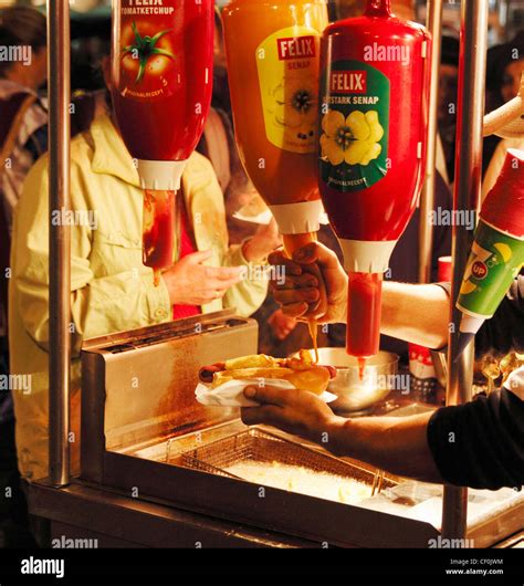 Squirting Mustard Onto Hot Dog At Hot Dog Stall In Street In Spain