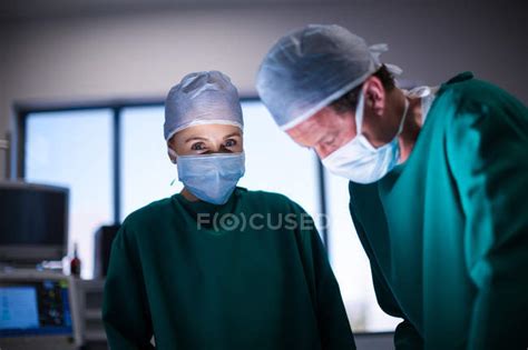 Male And Female Surgeons Performing Operation In Operation Theater Of