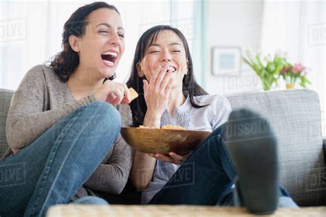 Women Laughing On Sofa Together Stock Photo Dissolve
