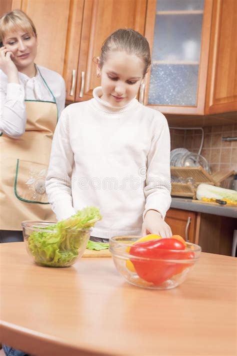 Young Caucasian Mother Teaching Her Teenage Daughter How To Cook Photos