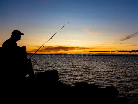 Fishing At Dusk Against A Vibrant Sky Stock Photo Image Of River