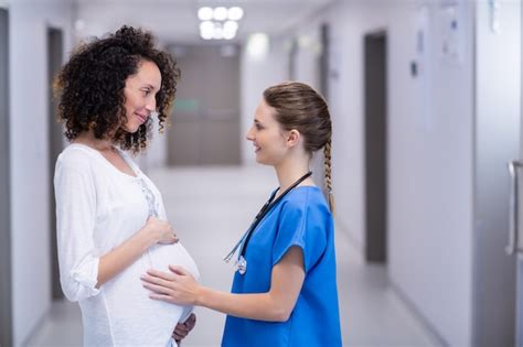Premium Photo Portrait Of Doctor Touching Pregnant Woman Belly In