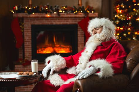 Santa Claus Relaxing At Home And Sleeping In Armchair Stock Photo