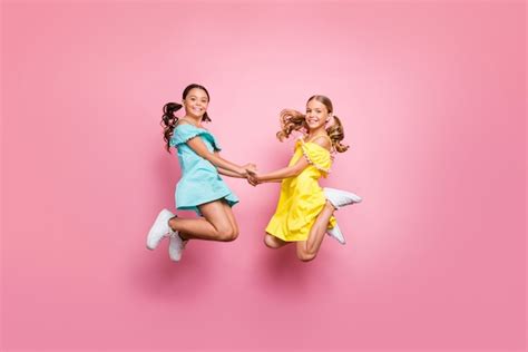 niñas con coletas posando contra la pared rosa foto premium
