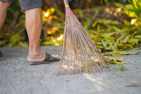 Premium Photo People Using A Broom Sweep The Leaves In The Courtyard
