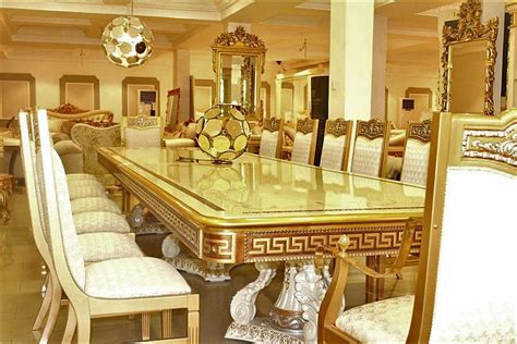 An Ornate Dining Room Table Surrounded By White Upholstered Chairs And