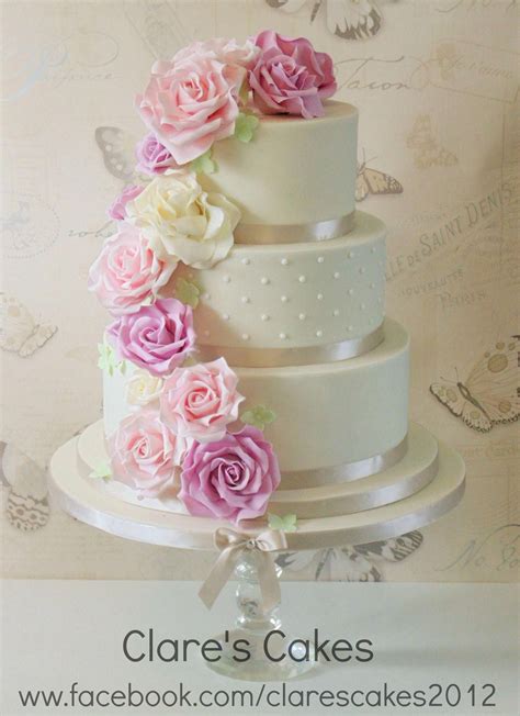 ivory wedding cake with pink lilac and ivory roses cascading down the 3 tier wedding