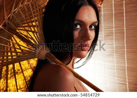 Sexy Tanned Brunette Woman With Umbrella In The Sunlight Going Through