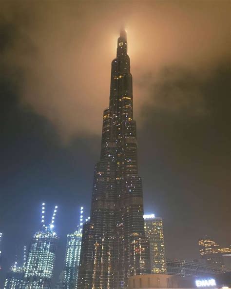 The Burj Building Is Lit Up At Night With Its Lights Shining On It