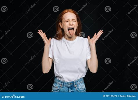 Angry Crazy Young Woman In T Shirt With Closed Eyes Spreads Hands To