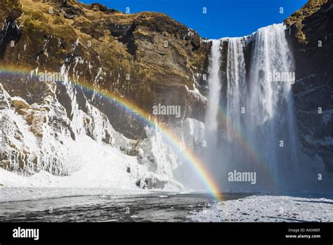 Skógafoss A Beautiful Waterfall With A Rainbow In The Spray Along