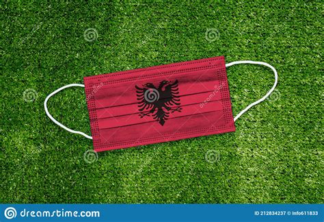 Flag Albania Placed On A Medical Mask Lies On The Green Grass Covid 19