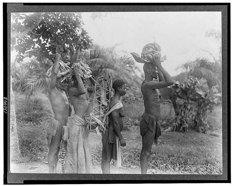 African Men And Woman Arriving At The Monthly Wild Rubber Village Market Carrying Rubber And