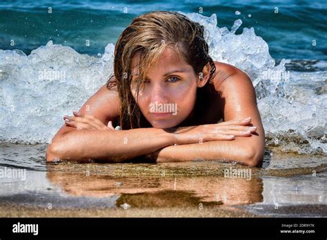 Portrait Of Woman Lying On Shore At Beach Stock Photo Alamy