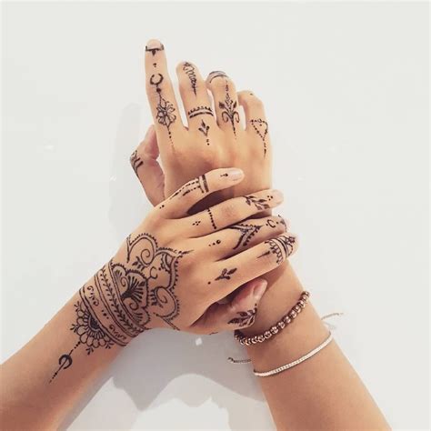 Two Hands With Henna Tattoos On Their Palms And Fingers Both Holding Each Other
