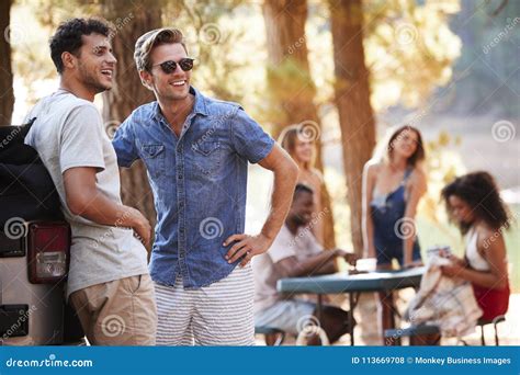 Two Young Men Hanging Out With Friends By A Lake Stock Photo Image Of