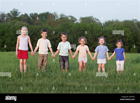 Portrait Of Children Holding Hands In A Field Stock Photo Alamy