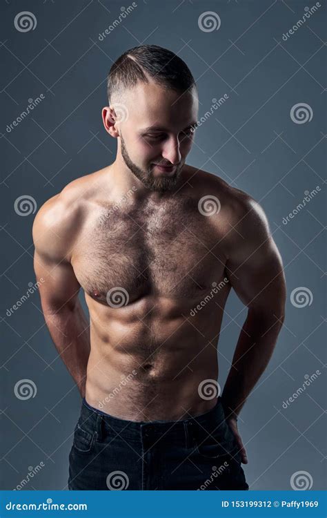 Muscular Shirtless Man Standing With Hands In Pockets Stock Photo