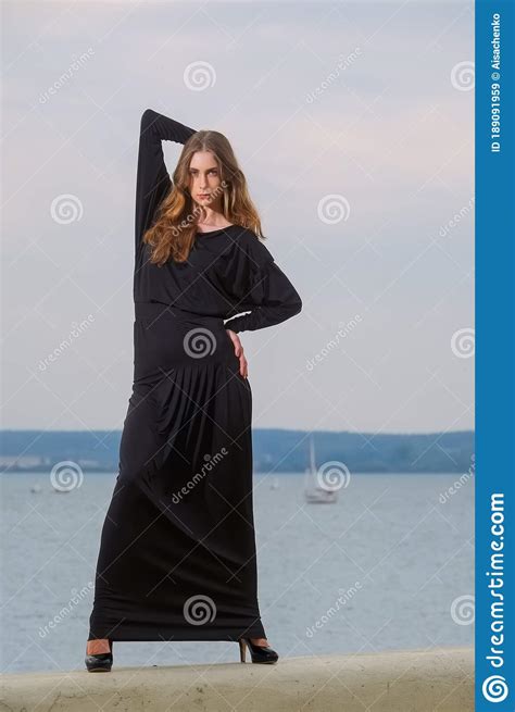 Attractive Fashion Model In Long Dress Posing On The Pier Stock Image