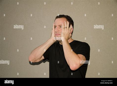 Shocked Man Alone With Hands On His Face Stock Photo Alamy