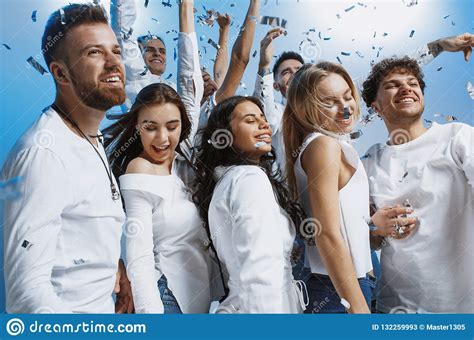 Group Of Cheerful Joyful Young People Standing And Celebrating Together Over Blue Background