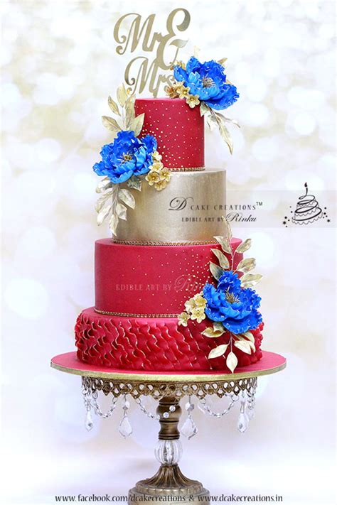 Red And Gold Wedding Cake With Royal Blue Flowers