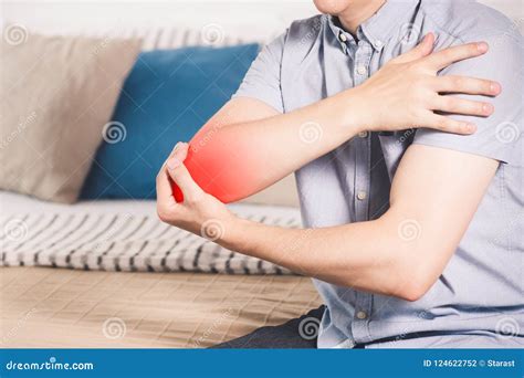 Man Suffering From Pain In Elbow At Home Joint Inflammation Stock