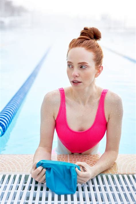 Pretty Awesome Ginger Woman Putting On Swim Cap At The Pool Stock Image