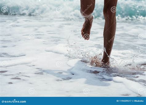 Feet Splashing Against Sea Waves On The Beach Summer Fun Concept